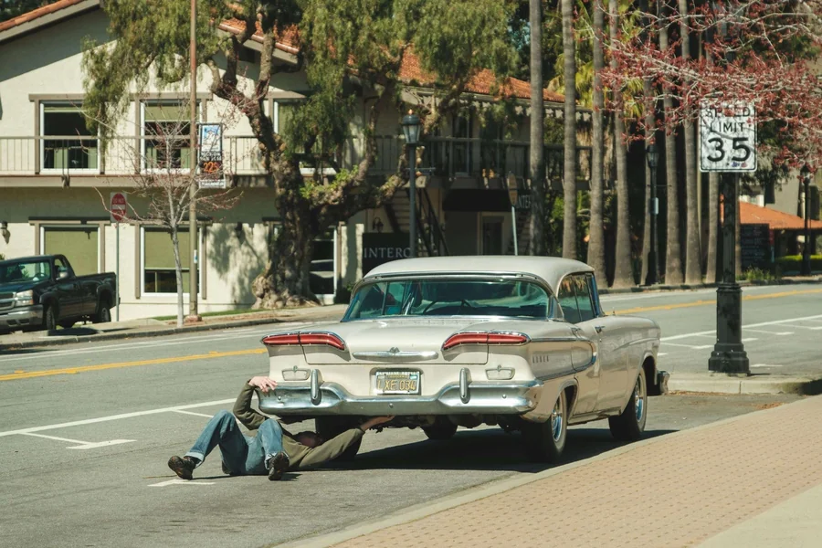 Driver inspecting a vehicle after multiple failed repairs, a common situation under California Lemon Law for Glendale car owners