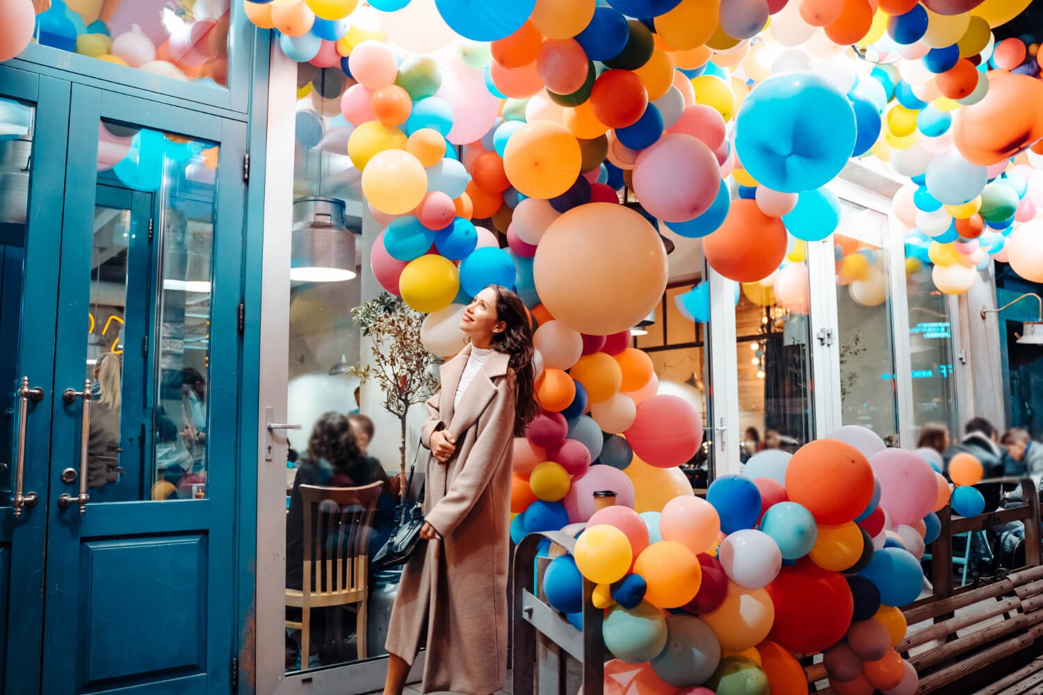 Professional balloon decor installation at an event venue showing colorful balloon arch and ceiling garland used for modern party decoration